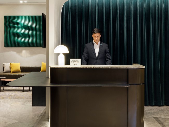 Concierge assisting a guest at the Le Méridien Melbourne lobby desk